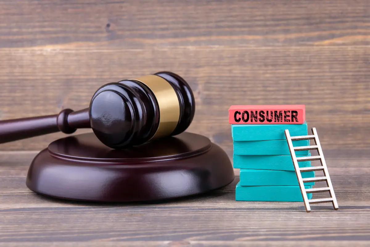 Consumer Rights Symbol – Gavel and Ladder of Justice Wooden gavel next to stacked blocks labeled consumer and a ladder symbolizing legal remedies